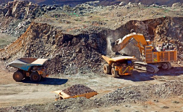 Open-pit mining operation with heavy machinery excavating and transporting material in Zimbabwe.