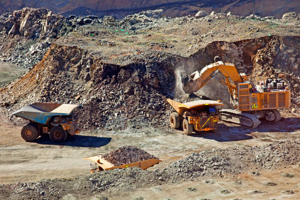 Open-pit mining operation with heavy machinery excavating and transporting material in Zimbabwe.