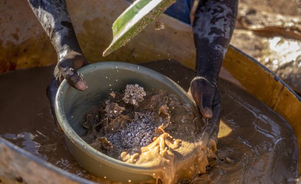 An artisanal gold miner sifts crushed ore by hand at a small-scale mine in Zimbabwe.