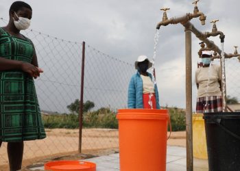 Residents collect water at a community water point in Zimbabwe.