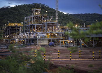 Industrial graphite processing plant with steel frameworks, pipes, and machinery in a hilly area of Cabo Delgado, Mozambique.