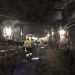 Underground mining tunnel at Blanket Mine in Zimbabwe, with workers in safety gear walking past conveyor systems.