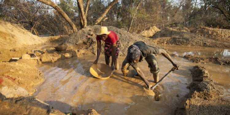 Artisanal gold miners process ore at a small-scale mining site in Zimbabwe