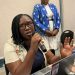 A speaker addresses a mining and human rights meeting in Harare, with participants listening in the background.