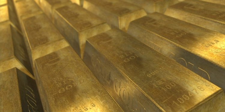 Stacked gold bullion bars stamped with weight and purity markings in a secure vault setting.
