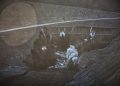 A controlled explosion in an open-pit mine sends dust and debris into the air.