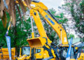Large yellow mining and construction vehicles displayed at an outdoor trade show