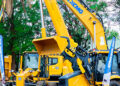Large yellow mining and construction vehicles displayed at an outdoor trade show