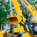 Large yellow mining and construction vehicles displayed at an outdoor trade show