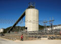 A woman walks past Anglo American Platinum's Unki mine in Shurugwi