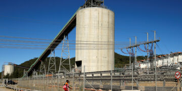 A woman walks past Anglo American Platinum's Unki mine in Shurugwi