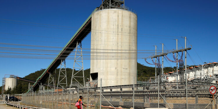 A woman walks past Anglo American Platinum's Unki mine in Shurugwi