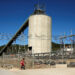 A woman walks past Anglo American Platinum's Unki mine in Shurugwi
