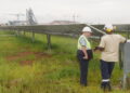 Two employees of the Pan African Resource’s gold mine talk in front of a solar farm used to power the gold mine in Mpumalanga, South Africa, February 1, 2023. Thomson Reuters Foundation/Kim Harrisberg
