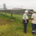 Two employees of the Pan African Resource’s gold mine talk in front of a solar farm used to power the gold mine in Mpumalanga, South Africa, February 1, 2023. Thomson Reuters Foundation/Kim Harrisberg