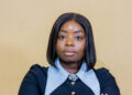 Eng. Gloria Gawe Bususu poses for a professional portrait with arms crossed.