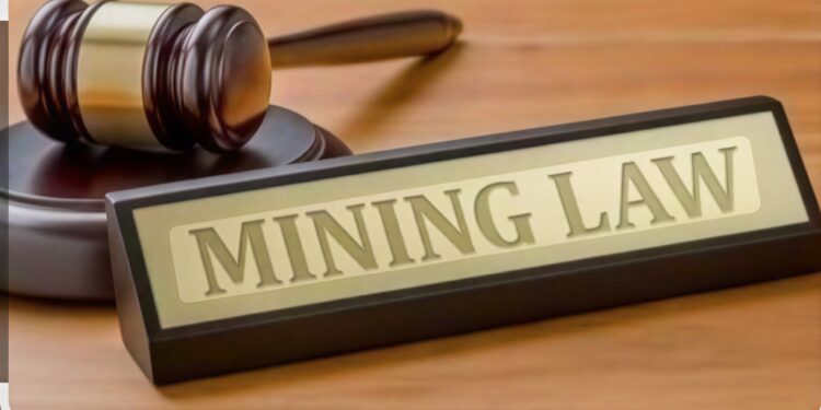 A judge's gavel beside a sign reading "Mining Law".