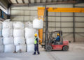 Forklift moves bulk bags of spodumene concentrate inside Bikita Minerals warehouse.