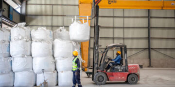 Forklift moves bulk bags of spodumene concentrate inside Bikita Minerals warehouse.