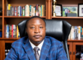Collins Takunda Mnangagwa, mining and energy executive, seated at a desk in an office with bookshelves