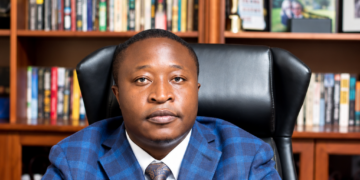 Collins Takunda Mnangagwa, mining and energy executive, seated at a desk in an office with bookshelves