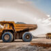 Large dump trucks transport platinum ore for processing at an open-pit mining operation in South Africa.