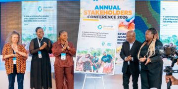 Delegates applaud on stage beside a poster for the planetGOLD Zimbabwe Annual Stakeholders Conference 2026