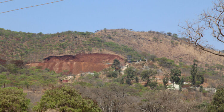 Christmas Pass Mountain near Mutare with a visibly disturbed section of hillside and exposed earth.