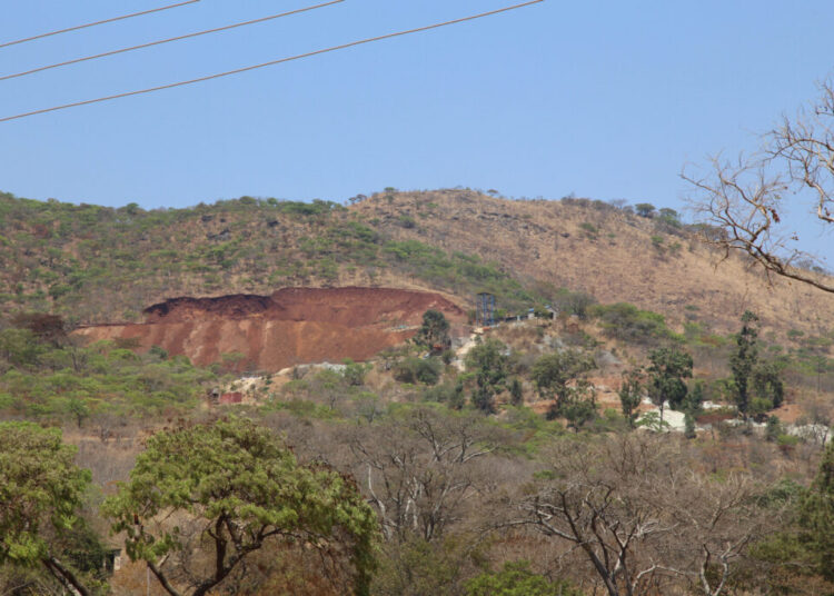 Christmas Pass Mountain near Mutare with a visibly disturbed section of hillside and exposed earth.